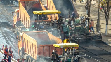 Çalışan işçiler finişer makineleri ve bahşiş asfalt yol yapımı sırasında ve tamir timelapse izleme ile çalışır