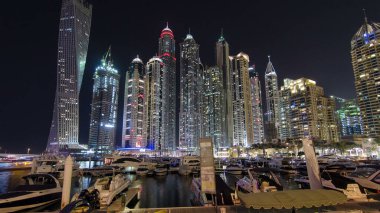 Dubai Marina 'nın en yüksek gökdelenleri, konut kuleleri ve tekneleriyle liman gecesi Dubai, Birleşik Arap Emirlikleri' nde hiper hız.