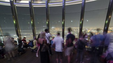 Burj Halife 'nin Üst Gözlem Güvertesi' nde gece kalabalıkla. Dubai, Birleşik Arap Emirlikleri zaman dilimi. Bakış açısıyla resim yapan bir sürü insan