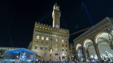 İtalya, Toskana, Floransa 'da alacakaranlıkta Piazza della Signoria' dan ünlü Arnolfo Palazzo Vecchio zaman atlaması kulesi. Tarihi binaların gece aydınlanması