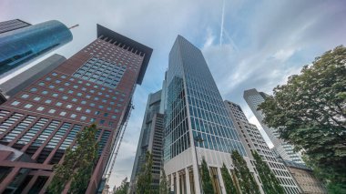 Hiperlapse, Frankfurt 'un Innenstadt bölgesindeki cam gökdelenlere bakıyor. Yüksek modern mimari, bulutları ufuk çizgisi boyunca yansıtır. Frankfurt am Main, Almanya.