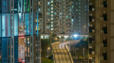 Yoldaki yoğun trafik gecelerinin en üst görüntüsü. Finans merkezindeki kuleler arasındaki zaman aralığı, Hong Kong şehrinin çatısı. Gökdelenler arasındaki üstgeçit