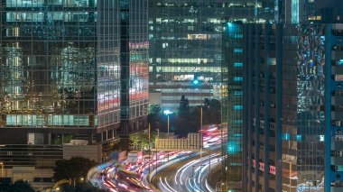 Yoğun trafik gece üstten görünüm Finans kentsel timelapse, hong kong şehir çatı kuleleri arasındaki yolda.