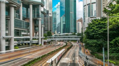 Hong Kong araba ve tramvay trafiği Hong Kong 'un merkez bölgesinde yağ aldırma kulesi yakınlarında. Gökdelenler, köprü ve gökyüzü Hong Kong için göz kamaştırıcı bir manzara. Caddenin üzerindeki yaya köprüsü