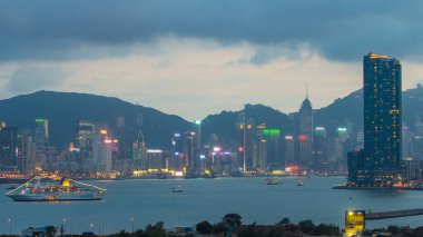 Hong Kong 'dan gece geçişi, Kowloon Körfezi' nden hava görüntüsü şehir merkezindeki zaman dilimi büyük gemi ve çatıdaki kuleler.