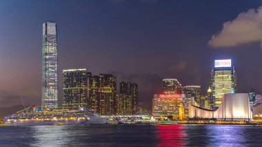 Hong Kong iş merkezi günden geceye geçiş zamanı bulutlu mavi bir gökyüzü ile, gün batımından sonra Hong Kong adasının birçok batı noktasından yansıması ile