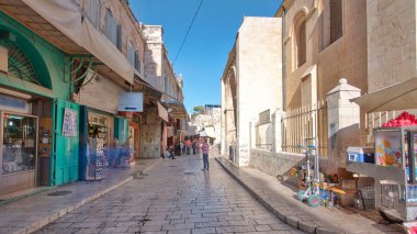 Kudüs 'ün eski kenti Kudüs' teki Kutsal Mezar 'ın yanındaki renkli çarşaf. İsrail zaman atlaması. Bu pazarda bir sürü insan geçiyor.