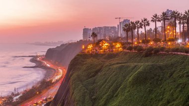 El Parque del Amor ya da Aşk Parkı, gün batımından sonra Miraflores 'deki geçiş zamanı, Lima, Peru. Kiss heykeli. Oturan ve yürüyen insanlar. Uçurumlarla dolu sahil şeridi