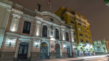 Merkez Postane Binası gece saatlerinde aydınlandı. Hipersürat, 1897 'de açıldı. Tarihi bina ve cadde trafiği. Lima, Peru