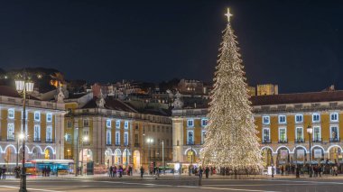 Lizbon 'daki ticaret meydanı, Noel' in aşırı hızıyla aydınlandı. Yükselen bir ağaç ve geceleri kutlayan kalabalıkla. Bir tepenin üzerindeki şenlikli atmosfer dekorasyonları ve tarihi mimarinin zamanı.