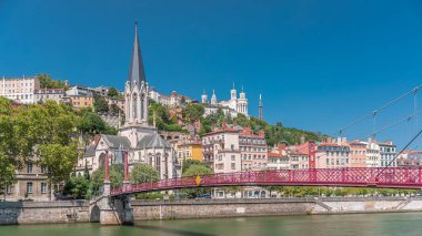 Aziz George Kilisesi, Quais de Saone ve Fourviere Bazilikası 'nın Fransa' nın Vieux Lyon kentindeki bir yaya köprüsünden hızlandırılmış zamanaşımı, tarihi mimari, yansımalar ve manzaralı nehir manzarası sergileniyor.