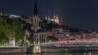 Aziz George Kilisesi, Quais de Saone ve Fourviere Bazilikası 'nın Fransa' nın Vieux Lyon kentindeki bir yaya köprüsünden hızlandırılmış zaman aşımına uğraması, geceleri tarihi mimari, yansımalar ve manzaralı nehir manzarası sergilenmektedir.