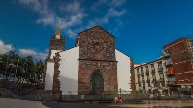 Funchal, Madeira Adası 'ndaki Katolik kilise cephesi, güneşli bir günde mavi bulutlu gökyüzü ile Portekiz zaman atlaması