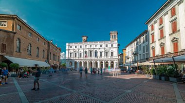 İtalya 'nın Bergamo kentinde bir panoramik zaman diliminde Vecchia Meydanı. Kütüphane, çeşme ve tarihi binalar. Yazın mavi gökyüzü