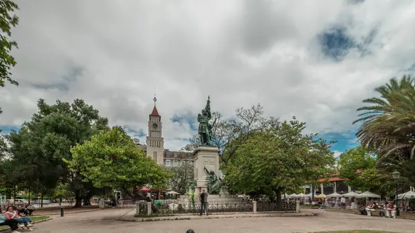 Dom Luis Garden, Lizbon 'un Baixa semtinde, Cais do Sodre tren istasyonu yakınlarında, arka planda şehir manzarası olan bir zaman atlaması yaşıyor. İnsanlar rahatlıyor ve bankta oturuyor.