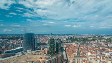 Milan 'da modern kulelerin, gökdelenlerin ve Garibaldi tren istasyonunun panoramik manzarası var. Kırmızı çatılı evler. Yazın mavi bulutlu gökyüzü