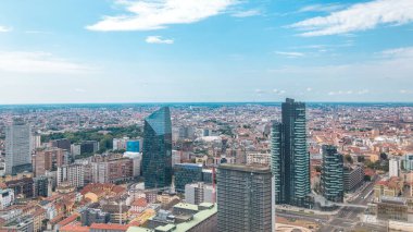 Milano 'nun panorama' sı modern kulelerin, gökdelenlerin ve Garibaldi tren istasyonunun çatıdan manzaralı manzarası. Kırmızı çatılı evler. Yazın mavi bulutlu gökyüzü