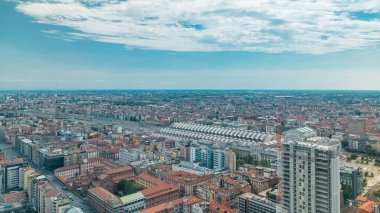 Milano 'daki konut binalarının ve merkez tren istasyonunun çatıdan iş bölgesinin zaman çizelgesi manzarası. Kırmızı çatılı evler. Yazın mavi bulutlu gökyüzü