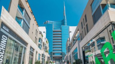 Gökdelen ve Milan finans bölgesine timelapse modern binalarda. Street mağazaları ile. İnsanlar burada yürümeye çalışıyoruz. Mavi bulutlu gökyüzü yaz gün