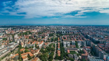 Milan 'ın iş bölgesinin yakınındaki yerleşim yerlerinin çatıdan zaman çizelgesi manzarası. Kırmızı çatılı birçok ev. Yazın mavi bulutlu gökyüzü