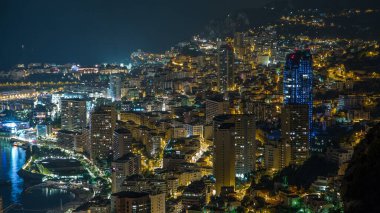 Monako 'nun havadan panoramik manzarası. Büyük Corniche Yolu' nun zaman çizelgesi, Monako Fransa. Binaları akşam aydınlatması. Yolda trafik vardı..