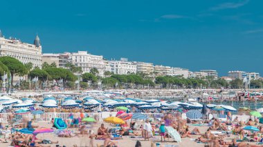 Fransa 'nın güzel bir yaz gününde Fransız Riviera' sında Cannes 'daki renkli eski kasaba binaları ve plajlar. Azur denizi, kumların üzerinde dinlenen insanlar.