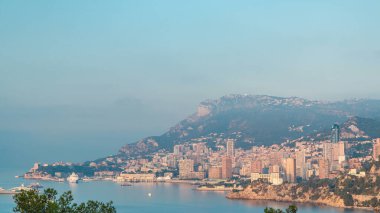 Monte Carlo 'nun şehir manzarası. Sabah sıcacık ışıklarıyla yaz gündoğumunda Monako' da. Sabah sisi ve bulutlar. Limandaki yatlar. Kaptan Martin 'den üst görünüm