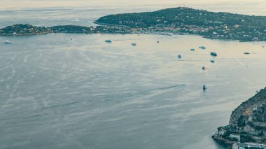 Akdeniz kıyı şeridi Saint-Jean-Cap-Ferrat 'ın havadan görüntüsü. Günbatımında Fransız Rivierası 'ndaki Eze köyünün tepesinden kayıklar ve ortaçağ evleri.