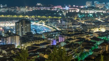 Monte Carlo 'nun şehir manzarası, Monako' da gece saatleri çatıları ve rıhtım trafiği. Tepelerden gökyüzü görüntüsü.