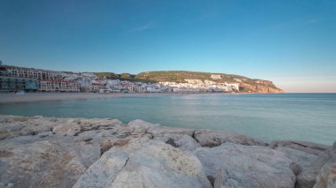 Sesimbra Portekiz 'in küçük bir kasabasında, iskeleden gün batımı tepede gölgeler, panoramik zaman dilimi