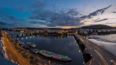 Ltava Nehri 'nin panoramik manzarası ve Prag Tepesi Petrin' in hava zaman çizelgesi ve Çek Cumhuriyeti 'nin güzel renkli gökyüzü ile Jirasek Köprüsü' nün gece gündüz geçişi. Dans salonunun tepesinden bak.