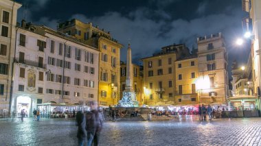 Rotonda square and Fountain timelapse near Pantheon at night light. Rome, Italy. People walking and sitting at fountain