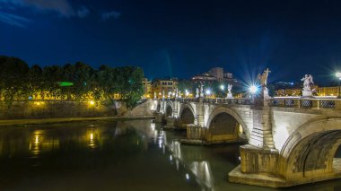 Ponte Sant 'Angelo Köprüsü zaman atlaması, Tiber Nehri' ni geçiyor. Castel Sant 'Angelo yakınlarındaki bir anıt mezar, şimdi bir müze ve sanat galerisi. Roma' nın göbeğinde geceleyin aydınlanıyor..