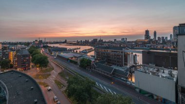 Rotterdam 'daki Katendrecht ve Maas Nehri gibi demirli gemilerle Maashaven' daki hava panoramik görüntüsü günden geceye geçiş zamanı. Eski fabrika yakınlarındaki trafik ofis ve etkinlik alanına dönüştü