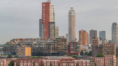 Rotterdam, Hollanda 'daki Katendrecht yarımadasının ve Maashaven limanının uçuş zamanı. Sabahları sıcak ışık, modern gökdelenler ve geleneksel Hollanda rıhtım evleri ile şehir silueti yükseliyor.