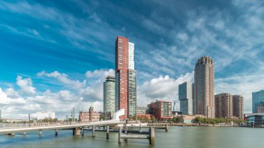 Hollanda, Rotterdam 'da bulunan ve yerel olarak Hoerenloper olarak bilinen Rijnhaven Köprüsü' nden Hiperlapse. Arka planda modern gökdelenleri ve bulutlu gökyüzü olan bir yaya ve bisiklet köprüsü