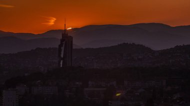 Saraybosna 'nın en popüler panoramik noktasından Saraybosna' nın en yüksek gökdeleniyle gün batımı manzarası. Sarı Kale (Zuta Tabija) yakınlarındaki yol, Vratnik