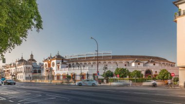 Plaza de Toros de la Real Maestranza de Caballeria de Sevilla zaman atlaması. İspanya 'nın Seville şehrinde boğa güreşi festivalleriyle tanınan tarihi boğa güreşi. Trafik ön cephesinin önünden geçiyor.