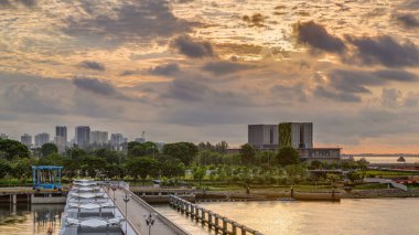 Marina Barrage 'da güzel bir gün doğumu zamanı. Turuncu gökyüzü ve güneş ışınlı bulutlar. Singapur 'un 15. su deposu ve şehrin göbeğindeki ilk su deposudur..