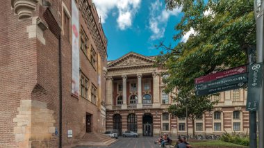 Rönesans zindanı ve Capitole arka tarafındaki klasik tuğla cephesi zaman atlaması, Fransa 'nın Toulouse belediyesi, Charles de Gaulle Meydanı' nda bulutlu bir gökyüzünün altında ağaçlarla çevrili.