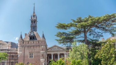 Rönesans zindan saat kulesi ve Capitole zaman atlamasının klasik tuğla cephesi Fransa 'nın Toulouse belediyesi mavi gökyüzünün altında Charles de Gaulle Meydanı' nda ağaçlarla çevrili.