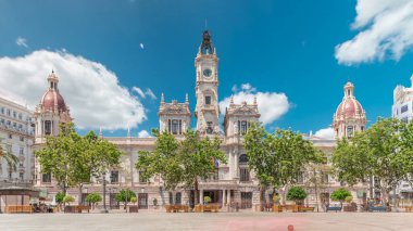 Valencia Belediye Binası (Ajuntament de Valencia) Plaza de Ayuntamiento 'da zamanaşımına uğradı. Mavi bulutlu gökyüzünün altında saat kulesi olan tarihi bir bina. İspanya 'nın ana meydanında gezinen insanlar