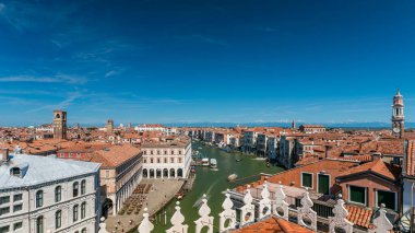 Top panoramic view on central busy canal in Venice timelapse, on both sides masterpieces of Venetian architecture, with lots of tourists sailing on gondolas and boats. Blue sky at summer day