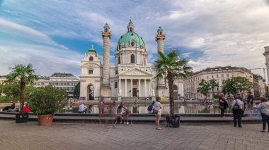Avusturya, Viyana 'da Karlsplatz Meydanı' nda Karlskirche. İnsanlar çeşmede yürüyor ve oturuyorlar. Tipik bir barok mimarisi olan Rektoratskirche adında Katolik bir kilisedir..