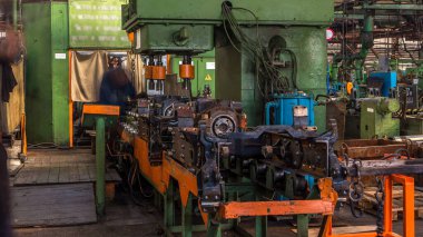 Konveyör montajı, traktörün gövdesini büyük endüstriyel fabrika zaman diliminde sahneleyecek. Üniformalı işçi tarafından Chassis ile çerçeve oluşturma