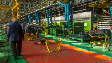 Konveyör montajı, traktörün gövdesini büyük endüstriyel fabrika zaman diliminde sahneleyecek. Çerçeve montajı, Chassis kurulumu ve diğer parçalar. Bir sürü işçi