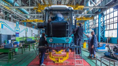 Konveyör montajı, traktörün gövdesini büyük endüstriyel fabrika zaman diliminde sahneleyecek. Çerçeve montajı, motor, egzoz borusu ve tekerlek kurulumu ve diğer bölümler.