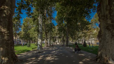 People walking around pavillion in Zrinjevac park timelapse hyperlapse in Zagreb, Croatia. Zrinjevac is spread over 12540 sq meters in city center. People relaxing on a bench