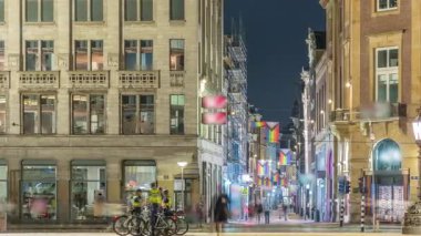 Amsterdam 'daki Baraj Meydanı' nda gece zaman dilimi, Hollanda. Şehrin tarihi merkezidir ve müzeler, dükkanlar ve oteller içerir. Aydınlatılmış Kalverstraat Caddesi