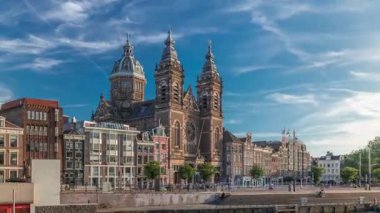 Merkez İstasyonu yakınlarındaki Amsterdam Eski Merkezi 'nde Aziz Niklas Bazilikası' nın hiperlapası. Tekne istasyonunun oradaki limanda yürüyen insanlar. Amsterdam, Hollanda